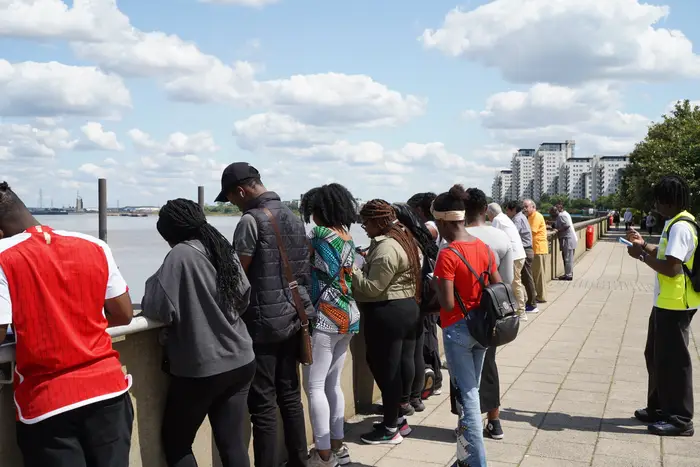 A group lined along the riverside railing